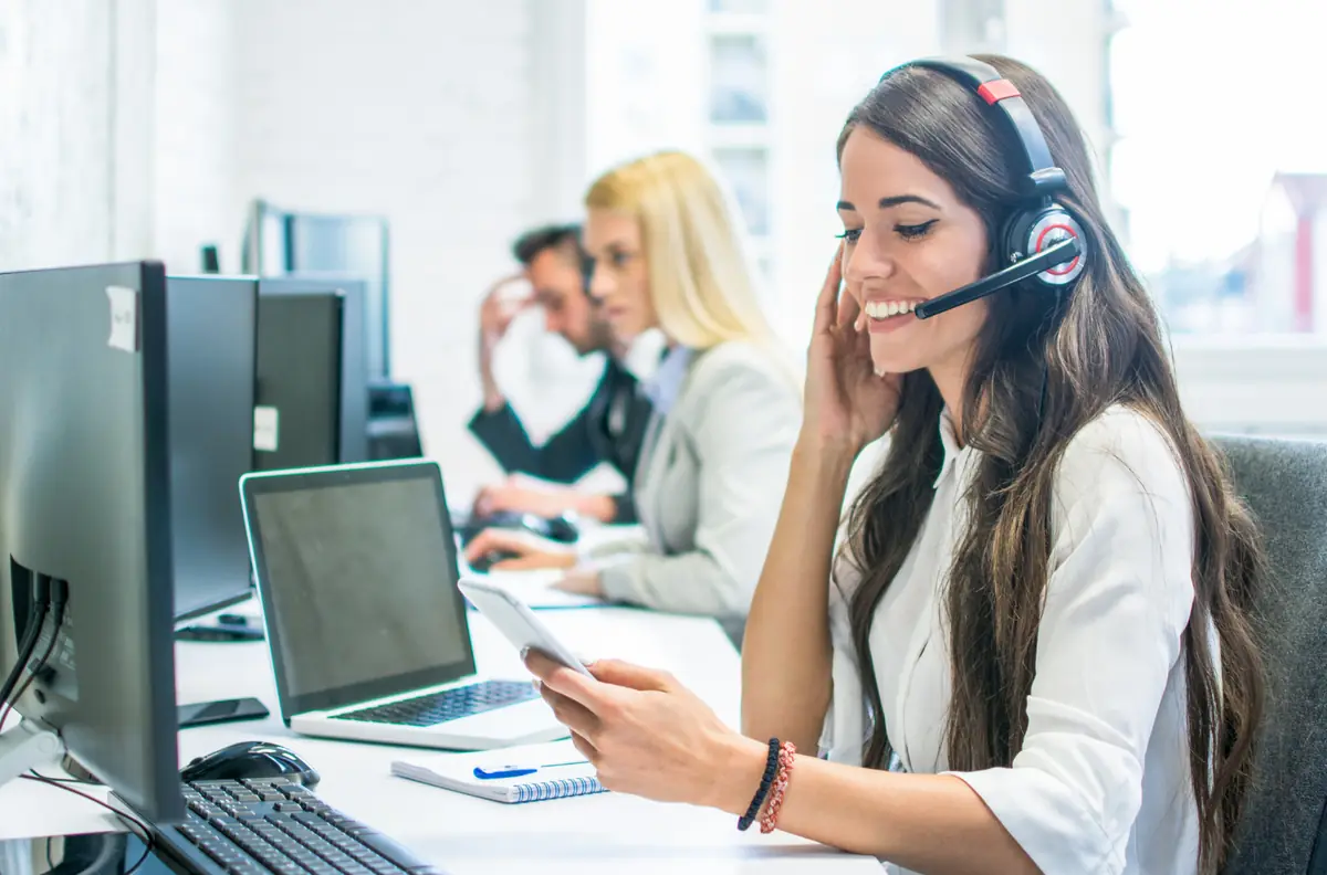 Chuyên viên hỗ trợ đeo tai nghe đang trả lời khách hàng
