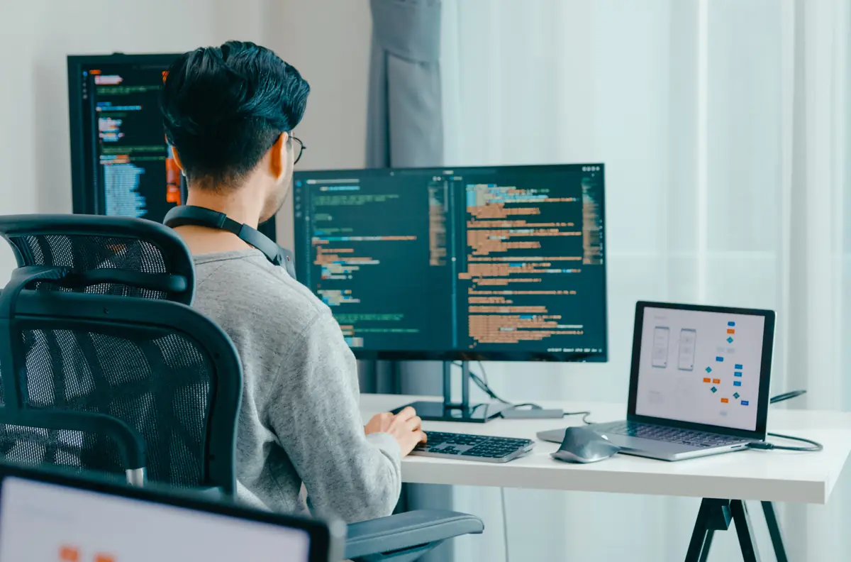 Nhà phát triển đang làm việc với mã website tại bàn đứng