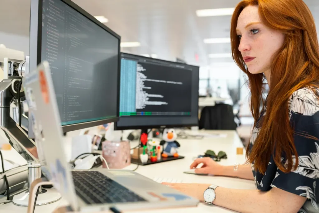 Developer reviewing WordPress code on two monitors