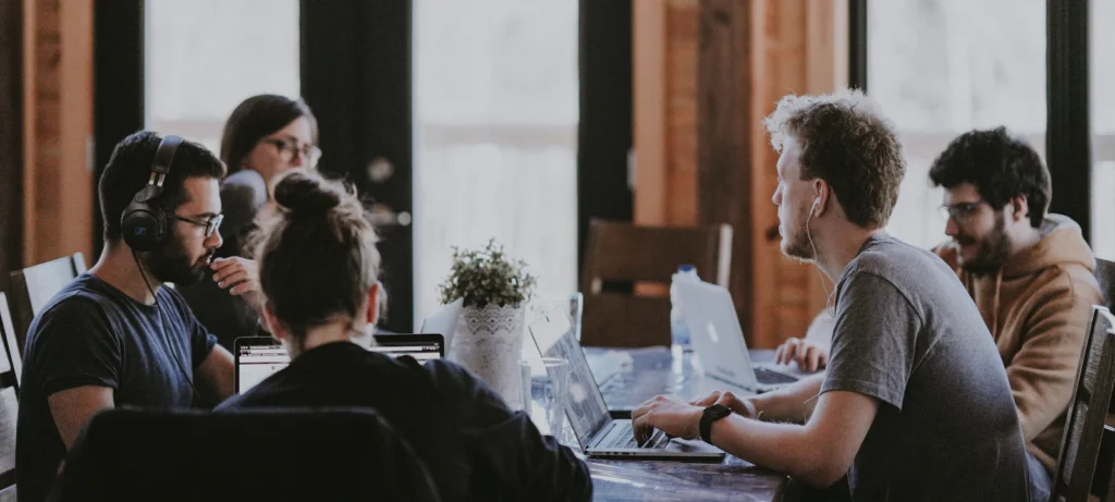 Team working on laptops around a shared table