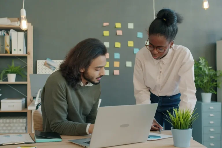 Two colleagues checking a website on a laptop